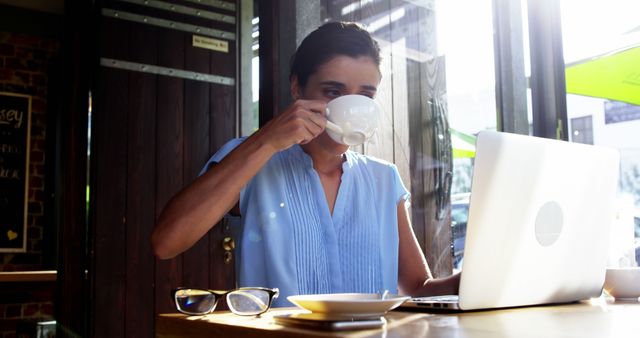 Woman Working on Laptop While Drinking Coffee in Cafe - Download Free Stock Images Pikwizard.com