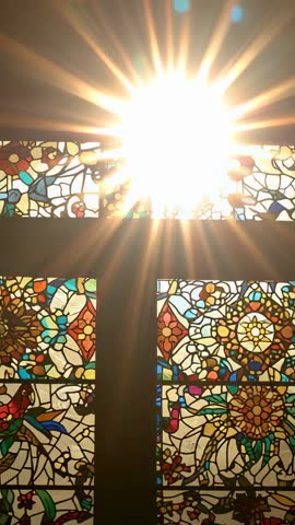 Sunburst Shining through Ornate Stained Glass Transom Vertical Video with Lens Flare