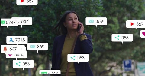 Millennial woman walking and talking while receiving social media notifications in city