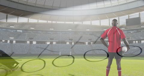 Rugby player analyzing game plan in large stadium