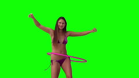 Woman Using Hula Hoop in Vibrant Green Environment