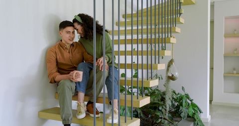 Young Couple Whispering Affectionately on Modern Floating Stairs
