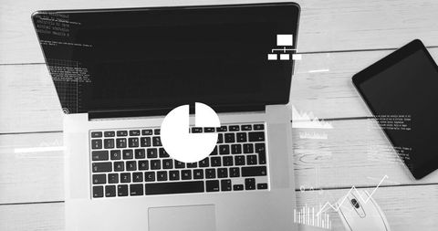 Laptop displaying analytics dashboard with code overlay, tablet and mouse on wood desk