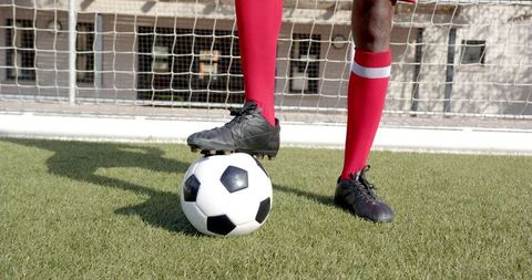 Soccer Player in Red Uniform Refreshingly Posing on Turf Field
