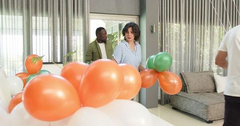 Colleagues prepping for office party with colorful balloons