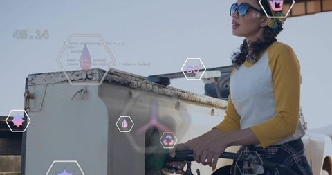 Young woman refueling car at outdoor pump wearing sunglasses and plaid shirt with ar icons