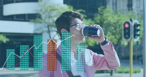Mature Asian professional drinking coffee from reusable mug with financial data overlay