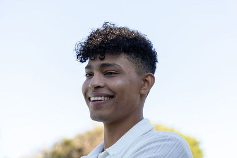 African american young man smiling outdoors casual portrait sunny park natural bokeh