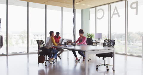 Diverse Team Collaborating in Modern Office Space with Laptops