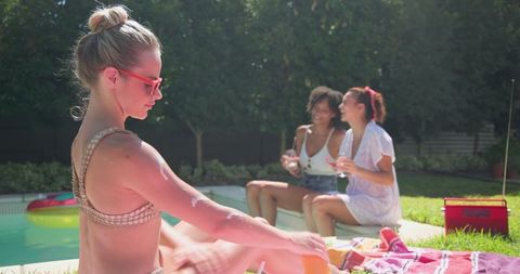 Women Relaxing by Poolside with Refreshing Drinks