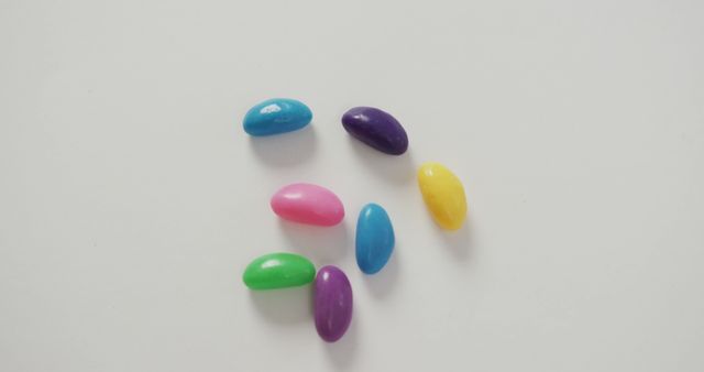 Image of overhead view of multi coloured jelly sweets over white background. fusion food and sweets concept.