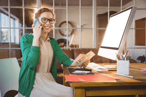 Professional woman talking on phone with transparent screen at desk