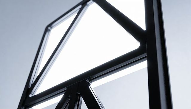 Showcasing Backlit Black Metal Frame with Geometric Glass Panes and Shiny Weld Details