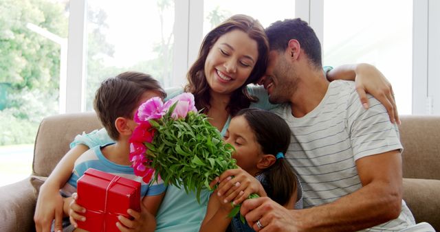 Happy Family Celebrating With Flowers and Gift in Cozy Living Room - Download Free Stock Images Pikwizard.com