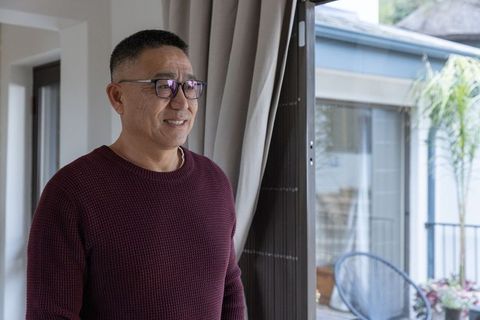 Senior asian man relaxing at home looking out window