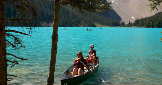 Couple Canoeing on Turquoise Lake Surrounded by Mountains - Download Free Stock Images Pikwizard.com