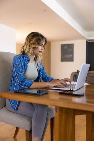 Woman Typing on Laptop in Modern Home Interior
