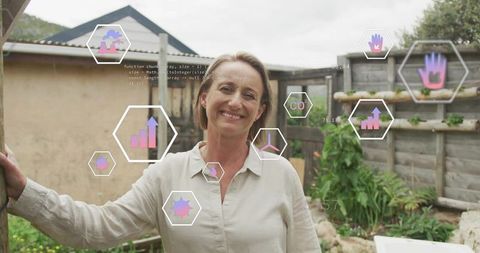 Smiling homeowner leaning on post in backyard showing augmented reality gardening analytics