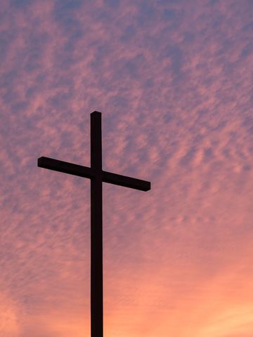 Silhouette of Christian Cross Against Vibrant Sunset Sky