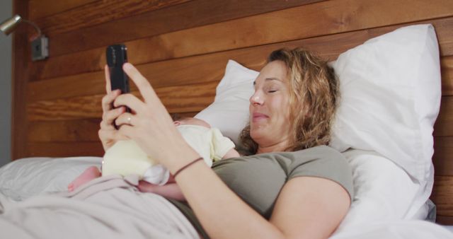 New Mother Relaxing on Bed with Baby and Using Smartphone - Download Free Stock Images Pikwizard.com