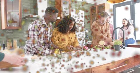 Friends preparing fresh salad at kitchen island during casual home cooking gathering in daylight