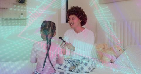 Mom playing pretend microphone with child on bed, cozy pajama morning family bonding