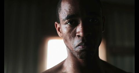 Determined Boxer with Focused Gaze in Fitness Studio