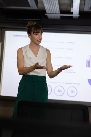 Businesswoman delivering corporate presentation in modern office