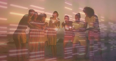 Friends holding sparklers on beach at sunset with neon light streaks, double exposure