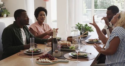 Joyful Group of Friends Sharing Lunch and Conversation at Home