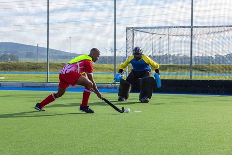 Intense field hockey competition on green turf