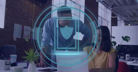 Collaborating on secure laptop with cybersecurity overlay in modern open-plan office