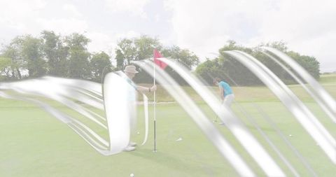 Senior couple playing golf on putting green holding flagstick and practicing precise putts