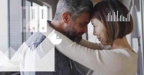 Mature couple embracing and touching foreheads in modern office with analytics overlays