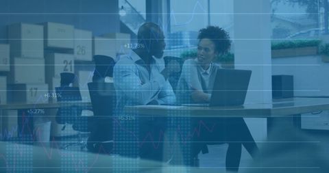 Diverse colleagues analyzing financial data on laptop in office
