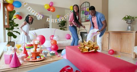 Family Cheerfully Cleaning After Birthday Celebration