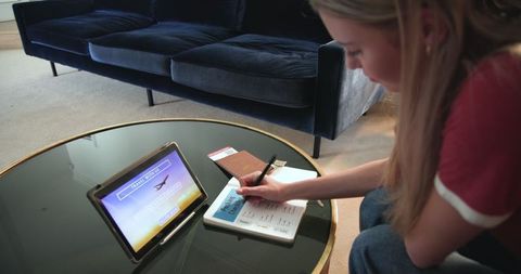 Teen Girl Planning Travel Itinerary Using Tablet at Home
