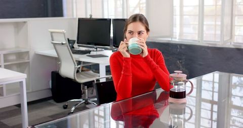 Woman enjoying coffee break at modern workspace