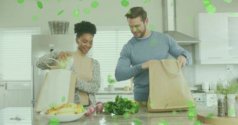 Couple unpacking groceries on kitchen island with reusable bags and fresh produce
