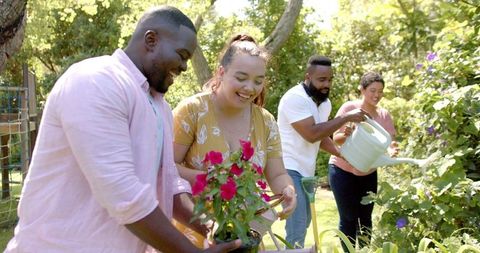 Diverse Friends Gardening Together in Lush Backyard Setting