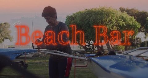 Woman adjusting rowing rig at dusk with neon beach bar glow and coastal boats