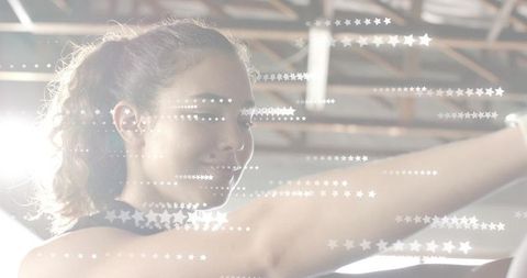 Young woman stretching forward in gym with dramatic backlight and star flare overlay