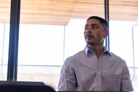 Focused Employee Working at Modern Office Desk by Large Windows