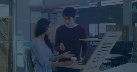Colleagues engaged in discussion at modern office workspace