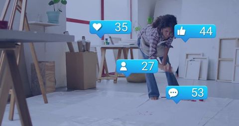 Artist creating red paint splatter in contemporary studio