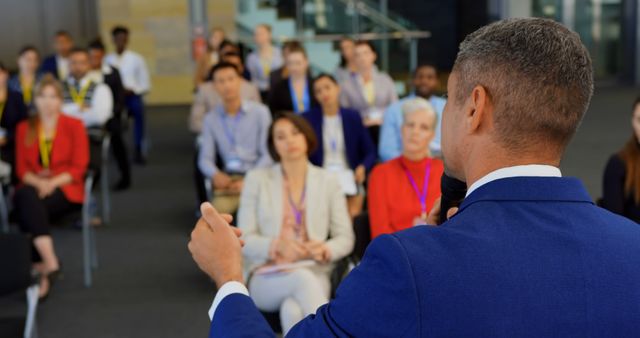 Rear view of a Caucasian male speaker speaking to the public in front of him in the business seminar 4k