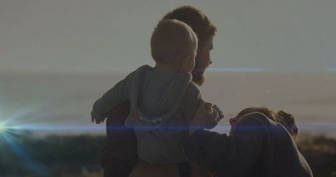 Family Bonding at Sunset: Parents and Baby at Dusk