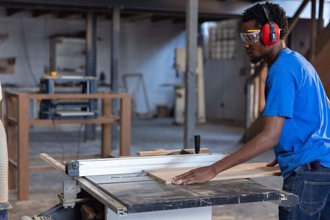 Cutting plywood on table saw with safety goggles and ear protection carpentry workshop