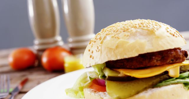 Close-Up of Tasty Cheeseburger with Fresh Vegetables on Plate - Download Free Stock Images Pikwizard.com