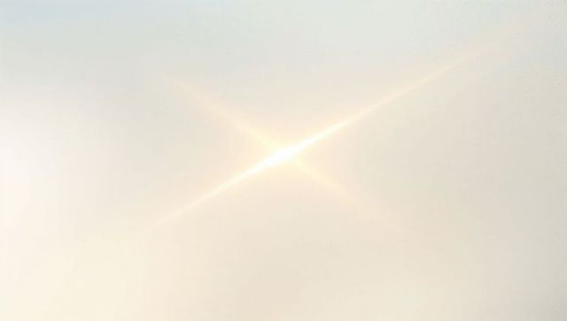 Minimalist X-Shaped Sunburst Flare with Soft Halo on Pale Gradient Sky for Modern Design
